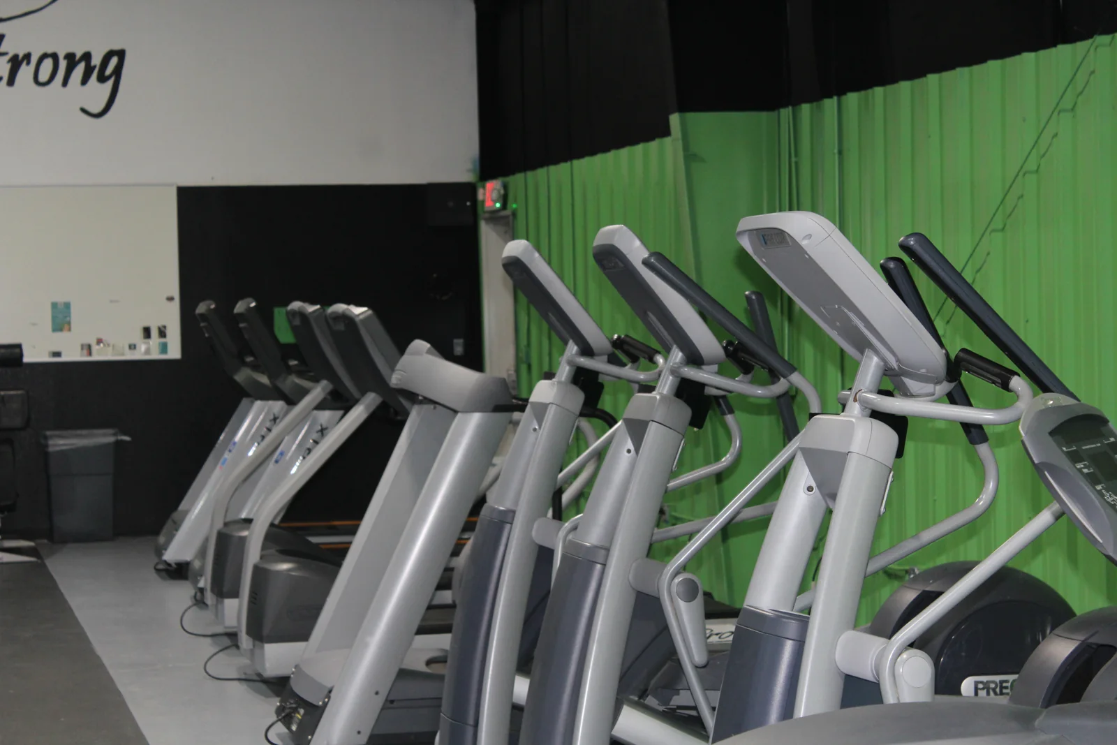 Cardio machines along the green wall at Van Buren Athletic Club